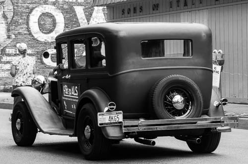 Classic car in parade. New Kensington Camera Club sign. Sons of Italy sign. 