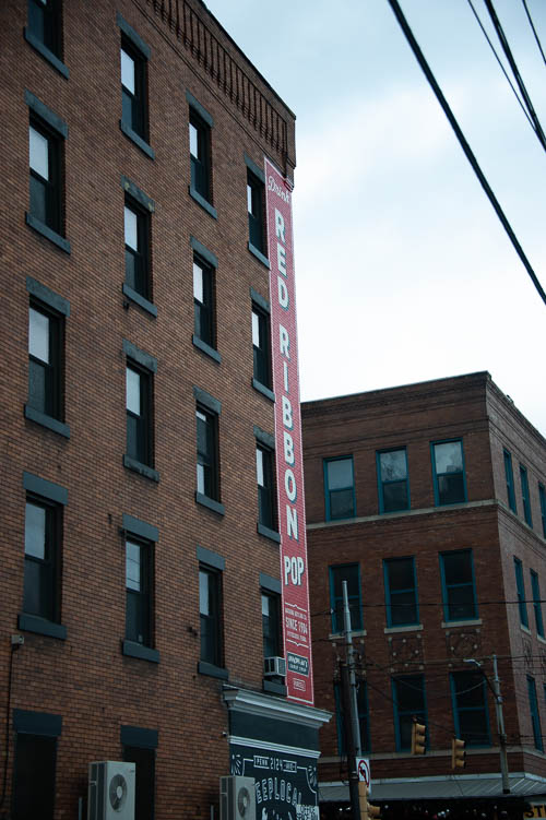 Brick building sign. Red Ribbon Pop. Strip District, Pittsburgh, Pennsylvania. April 28, 2018. 